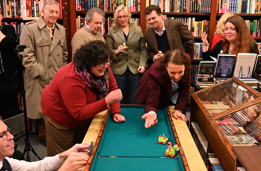 On January 11, during the 2nd running of the Wessex Cup at Otto Penzler’s The Mysterious Bookshop, Al Rosenblatt, Curtis Armstrong, Ashley Polasek, Matt Hall, and Peggy MacFarlane watch Madeline Quiñones and Monica Schmidt urge their wayward wind-up ponies to cross the finish line while Mark Jones records the progress of the race. Photo by Christopher Zordan.